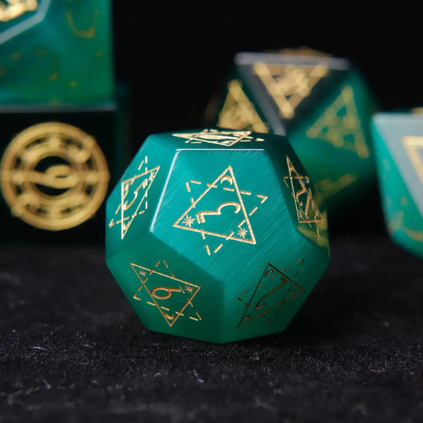 Detailed shot of the D12 die. The captivating cat's eye effect and deep engraved numbers are clearly visible against the dark gemstone.