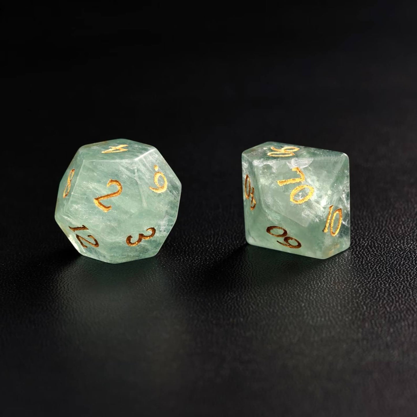 Lifestyle shot of the Green Fluorite polyhedral dice next to a D&D rulebook, positioning it as the best gift for Dungeons & Dragons fans.