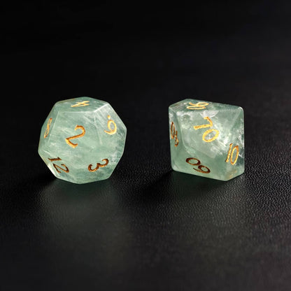 Lifestyle shot of the Green Fluorite polyhedral dice next to a D&D rulebook, positioning it as the best gift for Dungeons & Dragons fans.