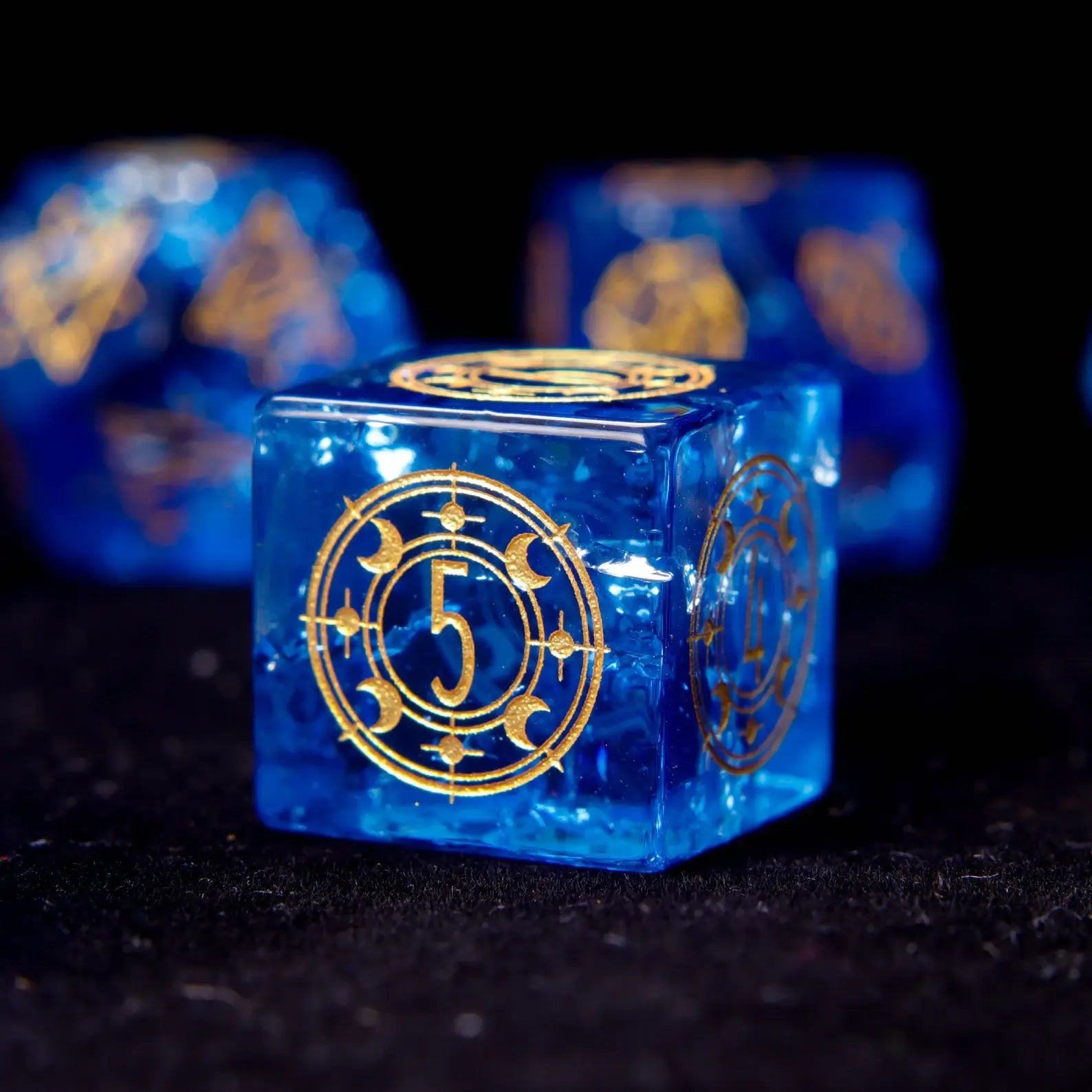 Single D6 sharp edge dice with engraved pips. The deep blue color and starry inclusions are visible even on the smaller die.