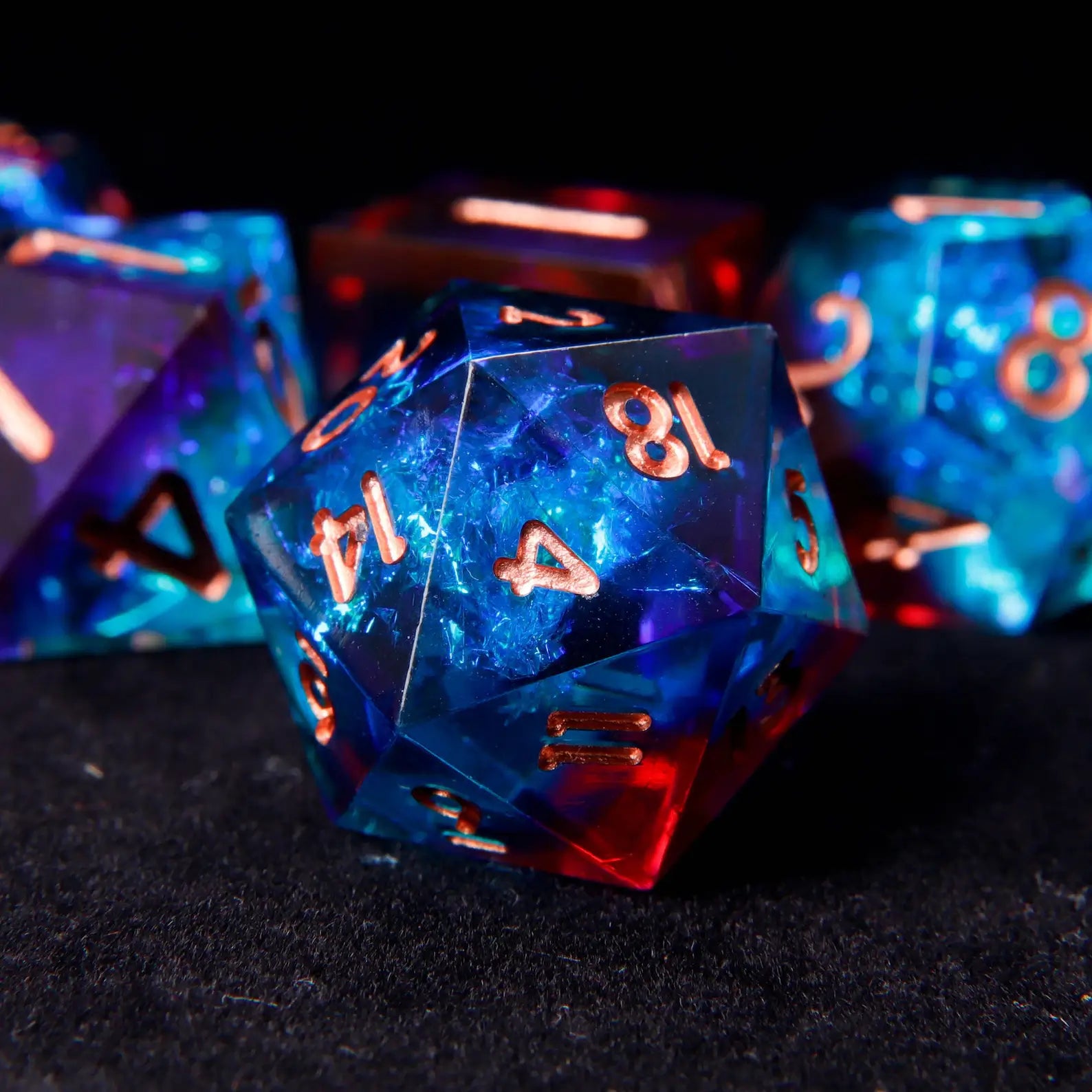  Close-up of a D20 die with intense blue-red laser iridescent coating and deep rose gold engraved numbers. Colors shift with light movement.