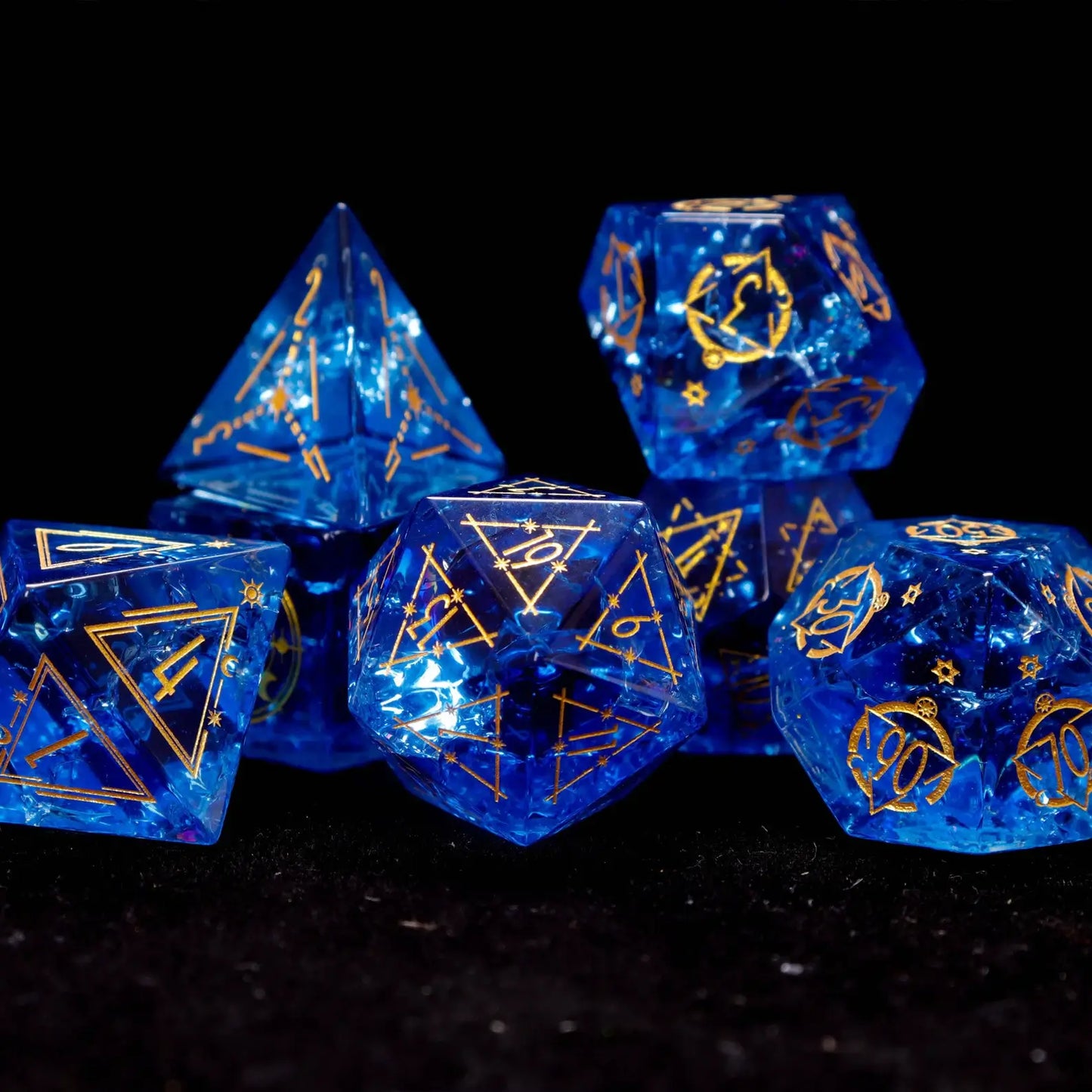 Artistic close-up of three key dice (D20, D6, D4) from the Blue Glass Sharp Edge DND Dice Set. Together they showcase the consistent sharp edges, starry depth, and luminous blue color of this premium DND dice collection.