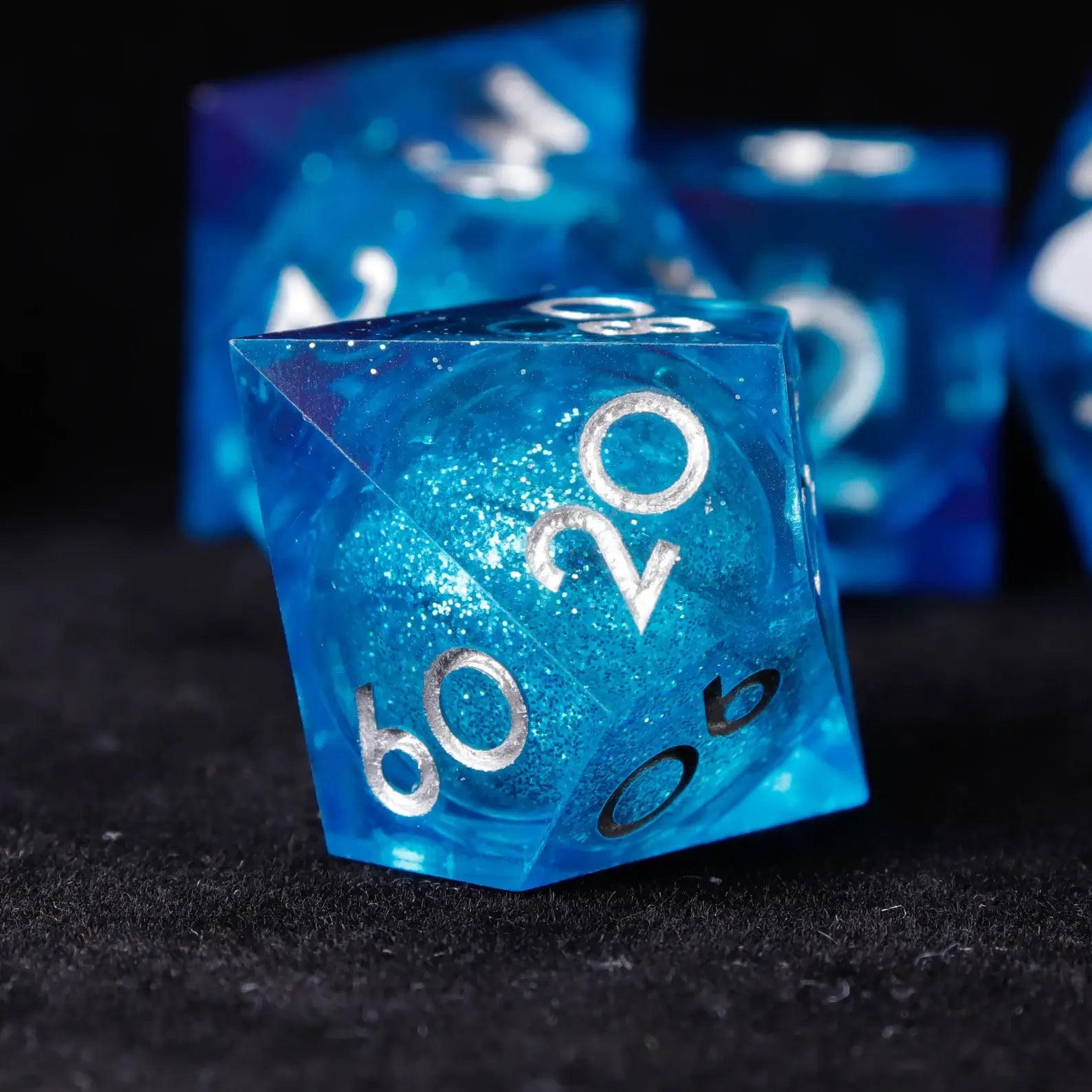 Blue Starry Liquid Core Resin D&D Dice Set displayed on gaming table with accessories