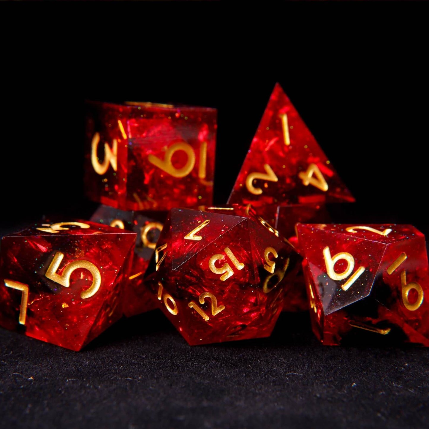 7-piece set of sharp edge DND dice in translucent fiery red solid resin with gold numbers.