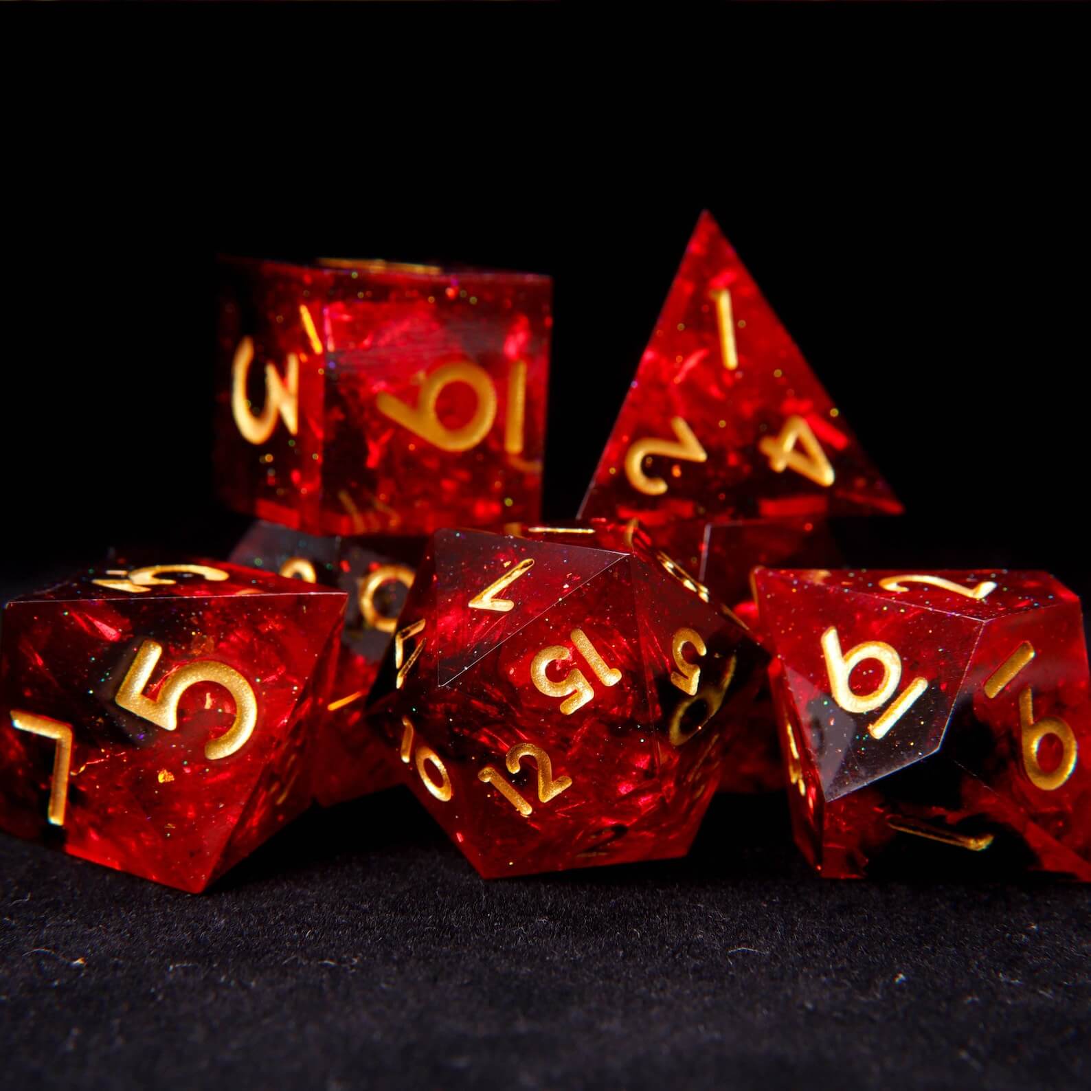 7-piece set of sharp edge DND dice in translucent fiery red solid resin with gold numbers.