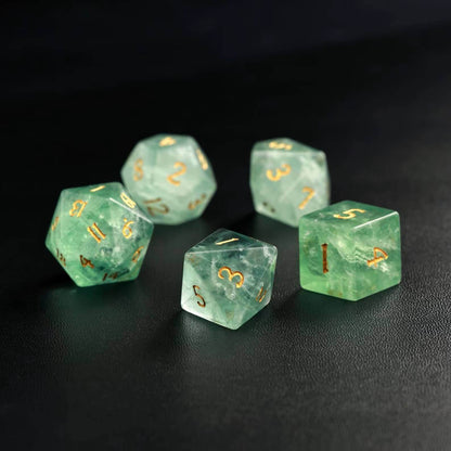 Side-by-side comparison image of the fluorite green dice next to a natural fluorite crystal specimen.