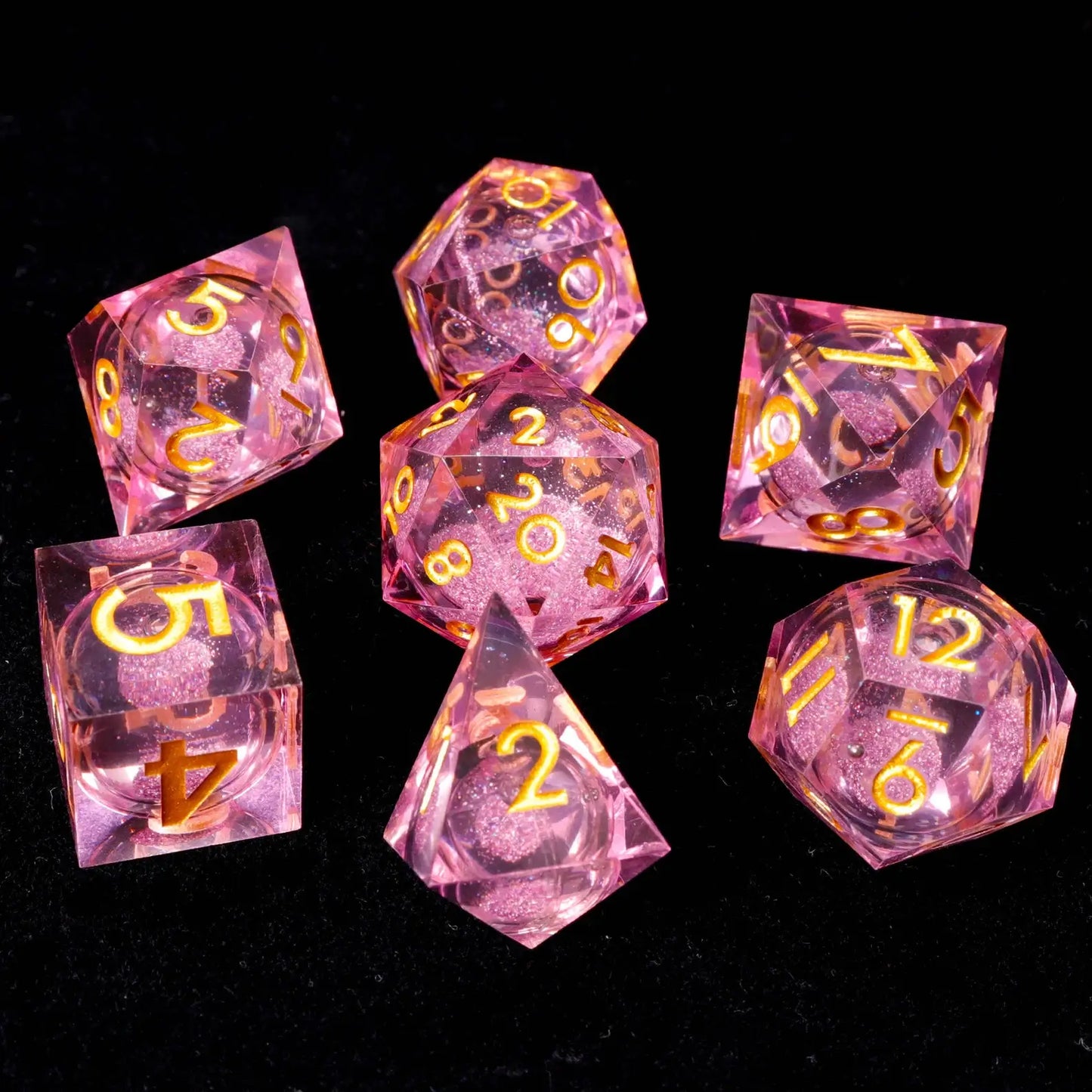 Detailed view of hand-engraved numbers on pink resin dice, with high-contrast white ink for easy readability against the pink background.