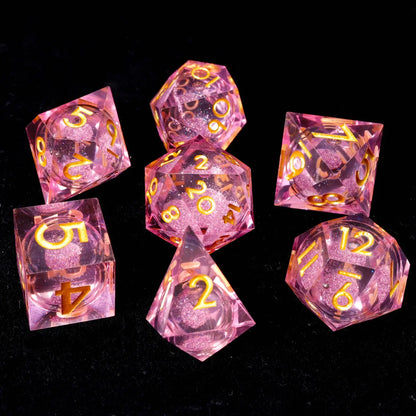 Detailed view of hand-engraved numbers on pink resin dice, with high-contrast white ink for easy readability against the pink background.