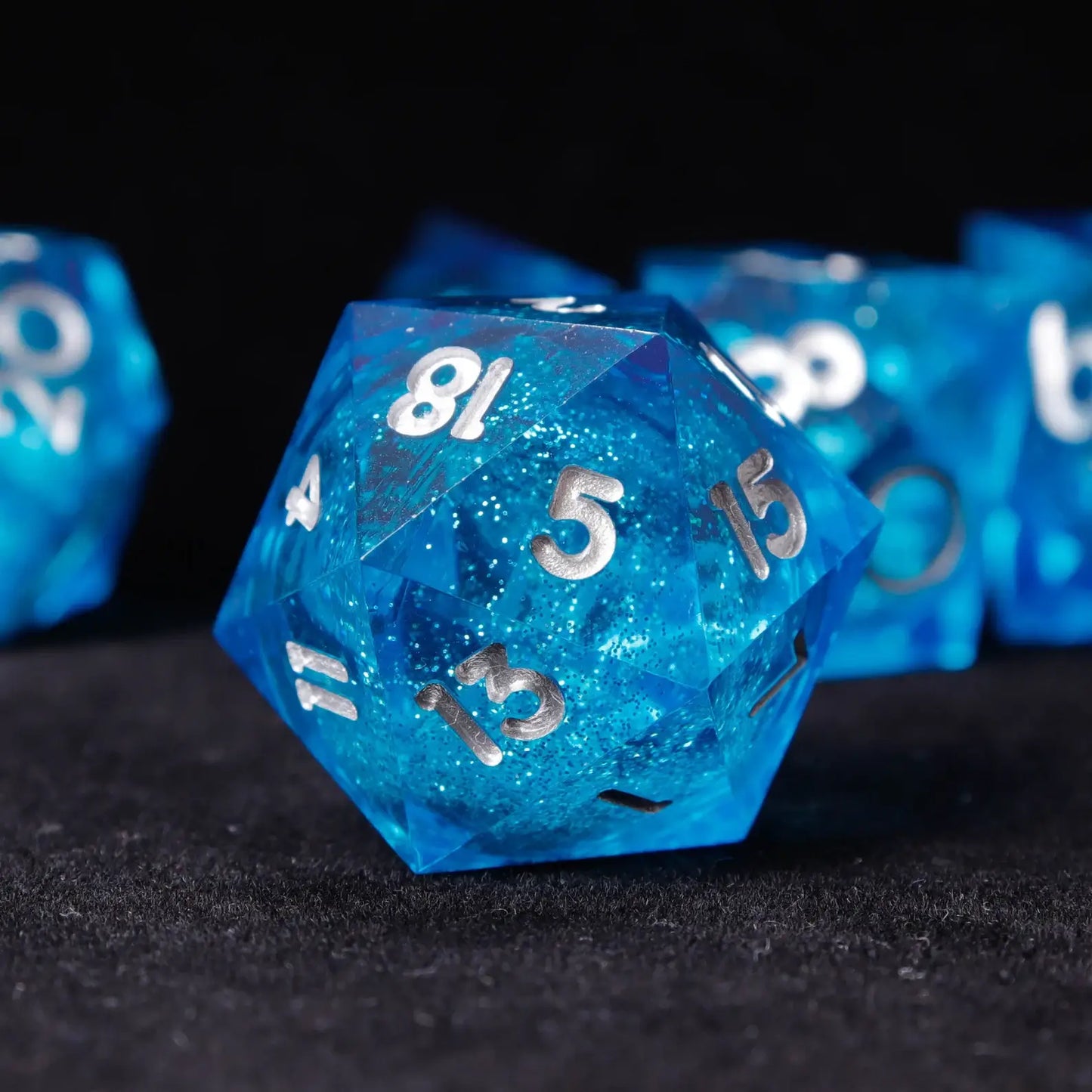 Single Blue Starry Liquid Core Resin Die at angled view showing transparent galaxy effect