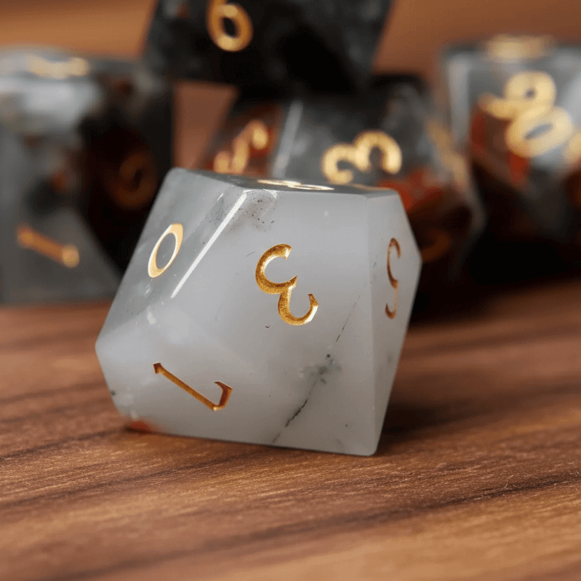 Grey Bloodstone percentile D10 dice (00-90 and 0-9) together on a walnut wood table.