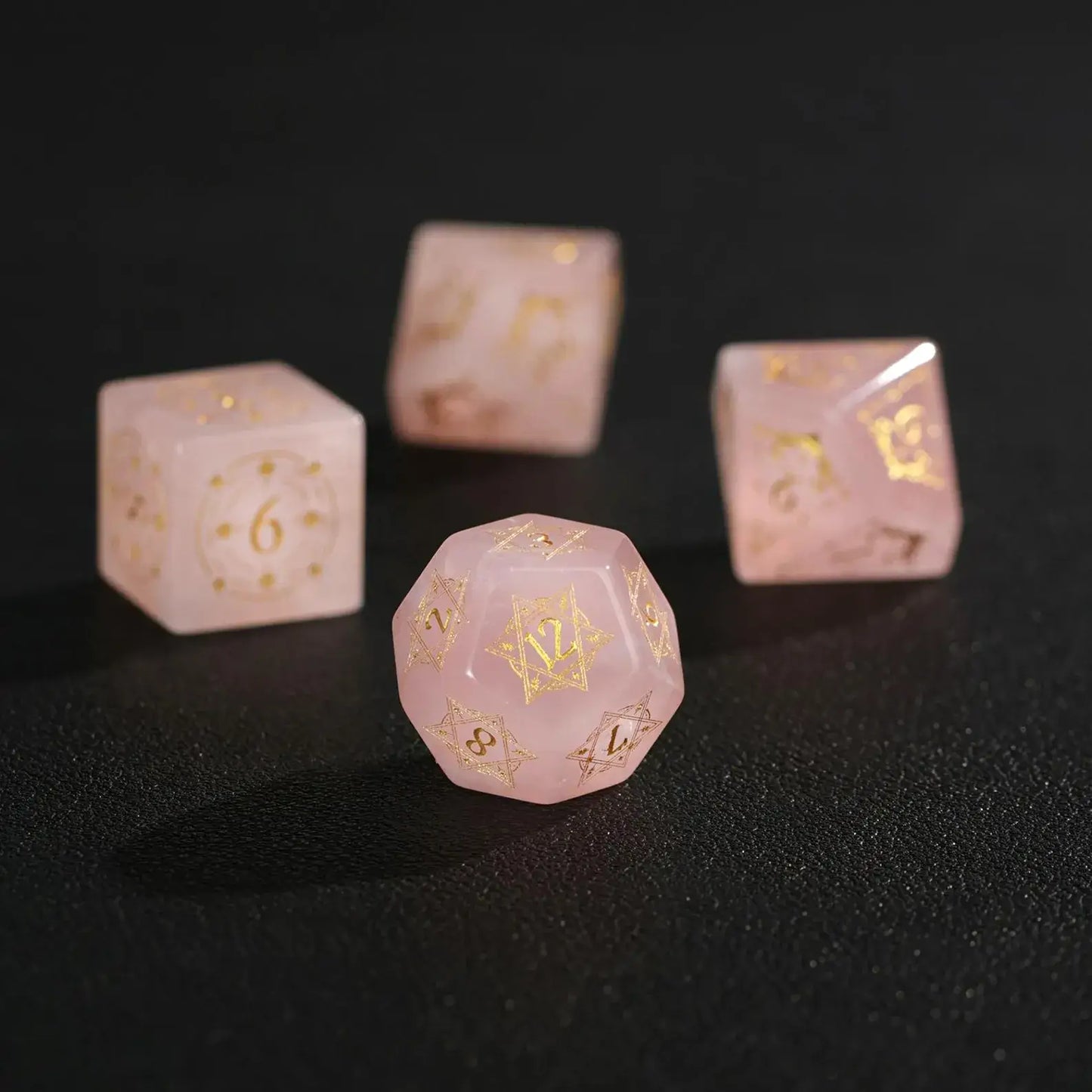 Extreme close-up macro of a Pink Crystal D12 dice on black, highlighting the deep engraving and internal crystalline veins.