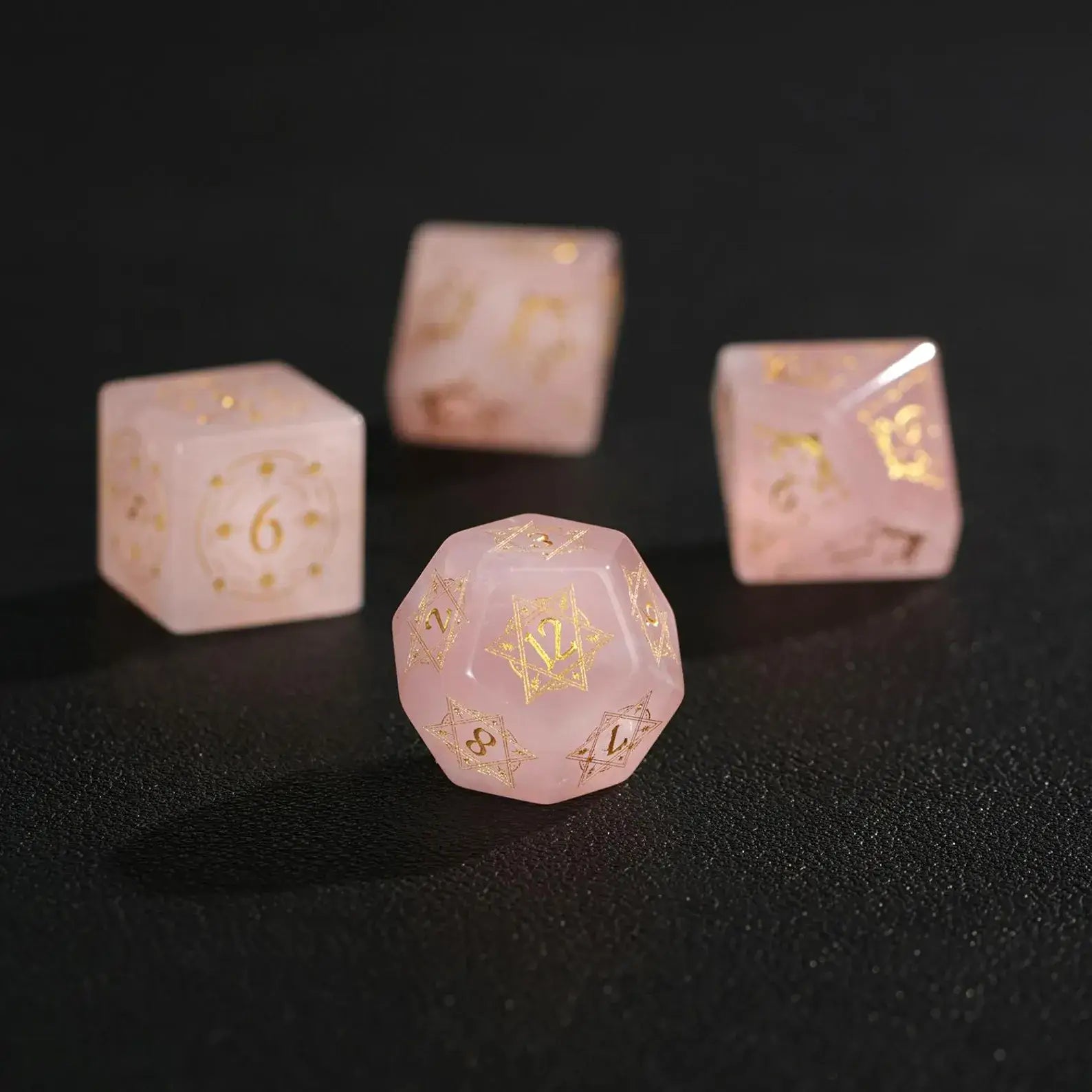 Extreme close-up macro of a Pink Crystal D12 dice on black, highlighting the deep engraving and internal crystalline veins.
