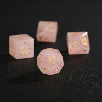 Extreme close-up macro of a Pink Crystal D12 dice on black, highlighting the deep engraving and internal crystalline veins.