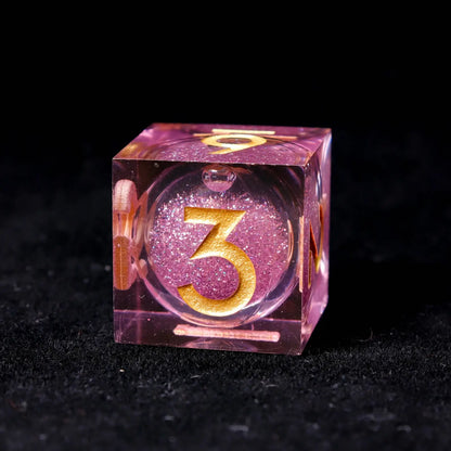 Comparison of pink liquid core dice at rest and after a roll, highlighting the several seconds of sustained glitter motion.