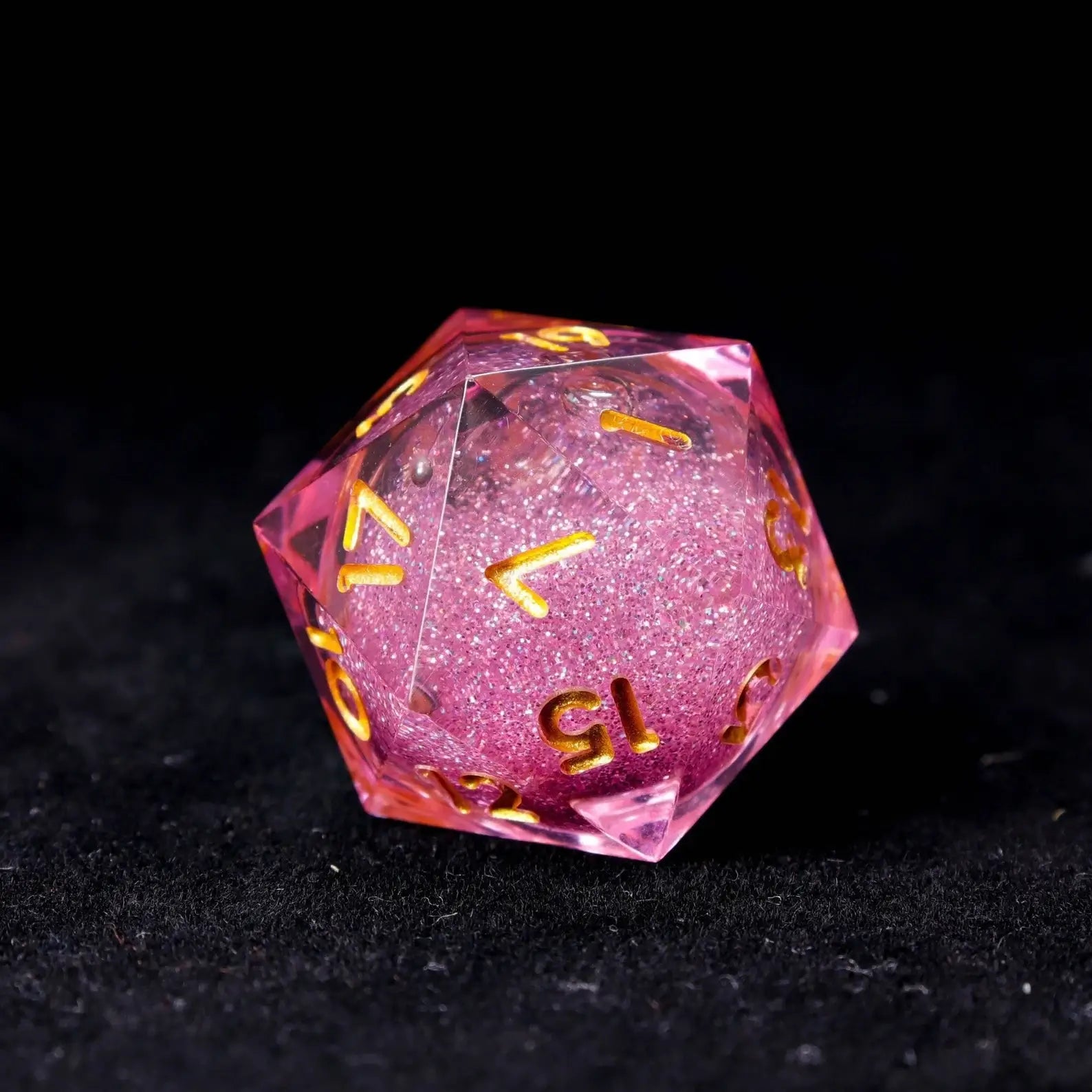 Close-up of the swirling glitter effect inside a pink liquid die, creating a dynamic visual resembling a pink nebula.