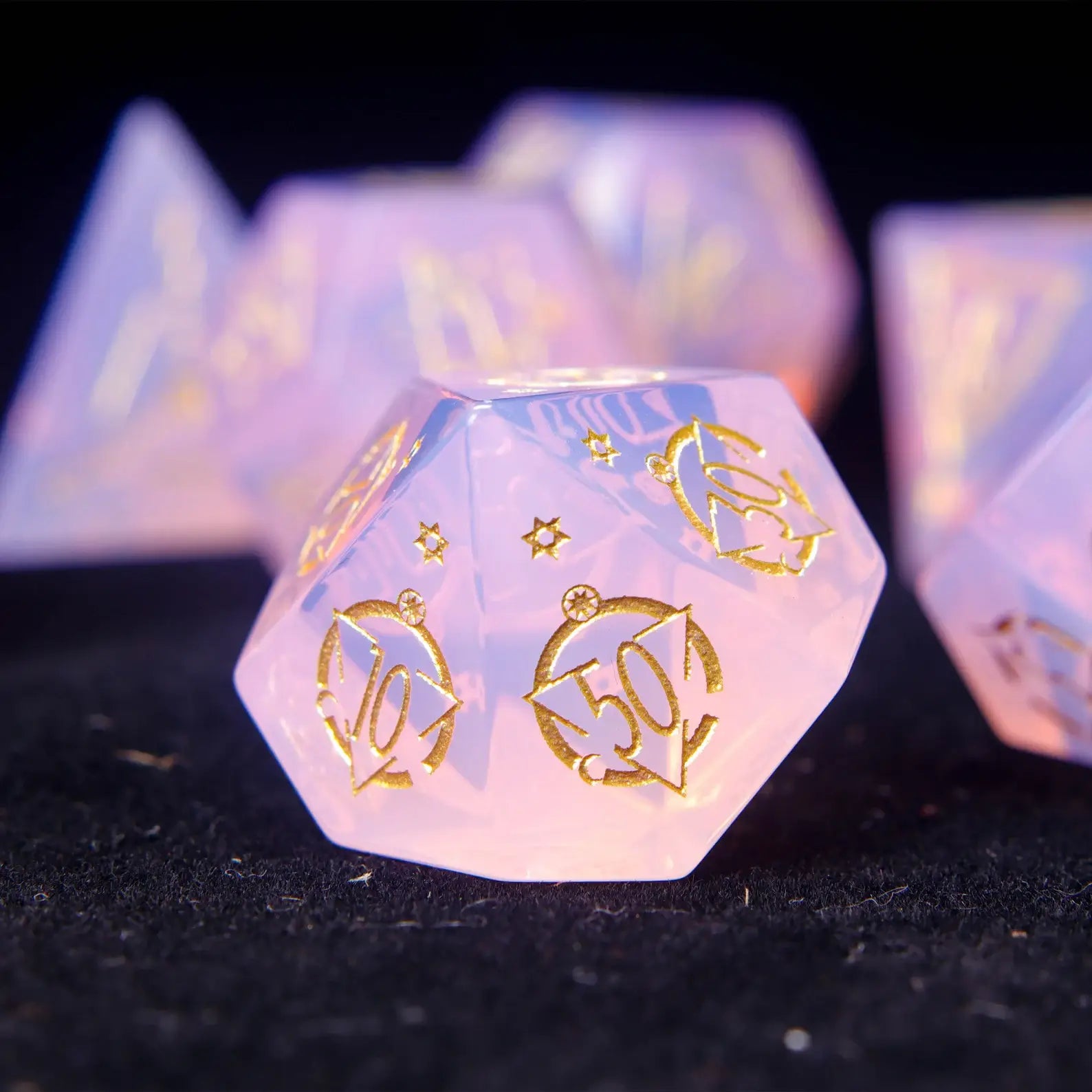 Pink opal D% percentile die with shimmering carved surface.