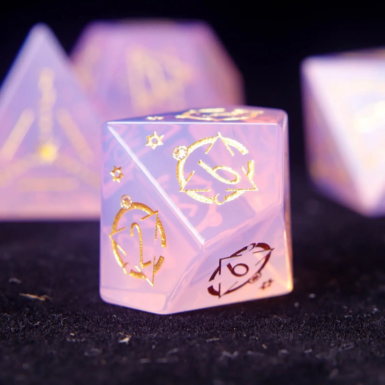 Pink carved opal D10 featuring iridescent opal veins and triangle etching.