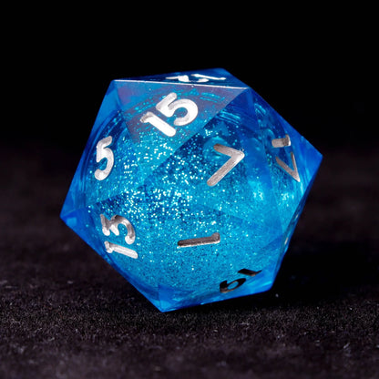 Close-up of a blue liquid core D20 with glitter and engraved numbers
