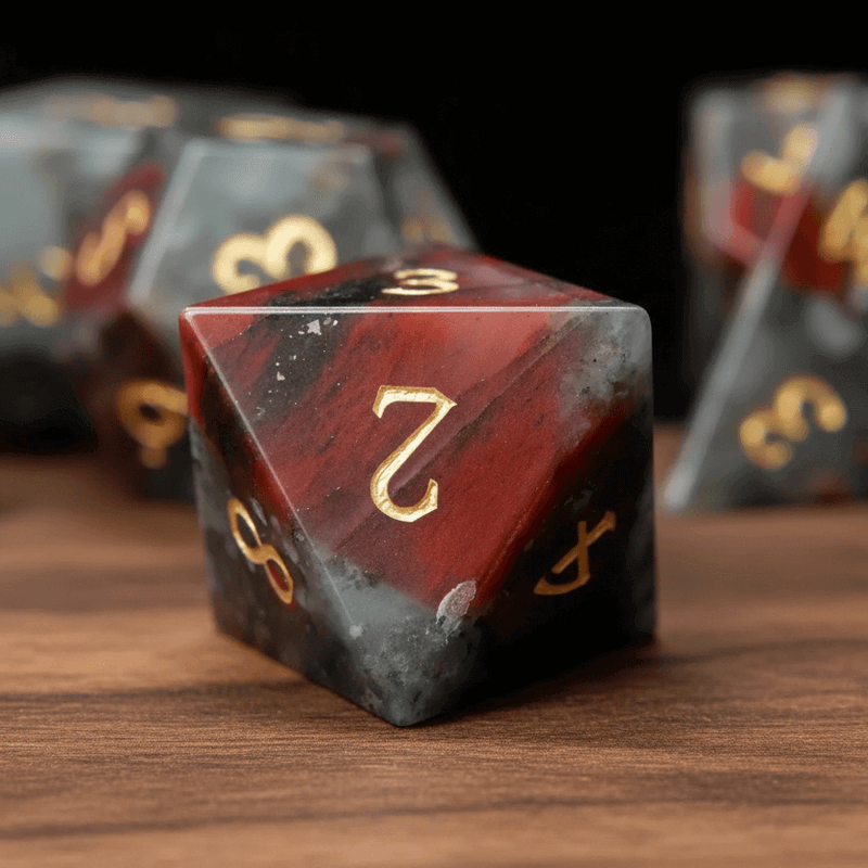 Single Grey Bloodstone D8 die showing engraved numbers and faces on walnut wood.