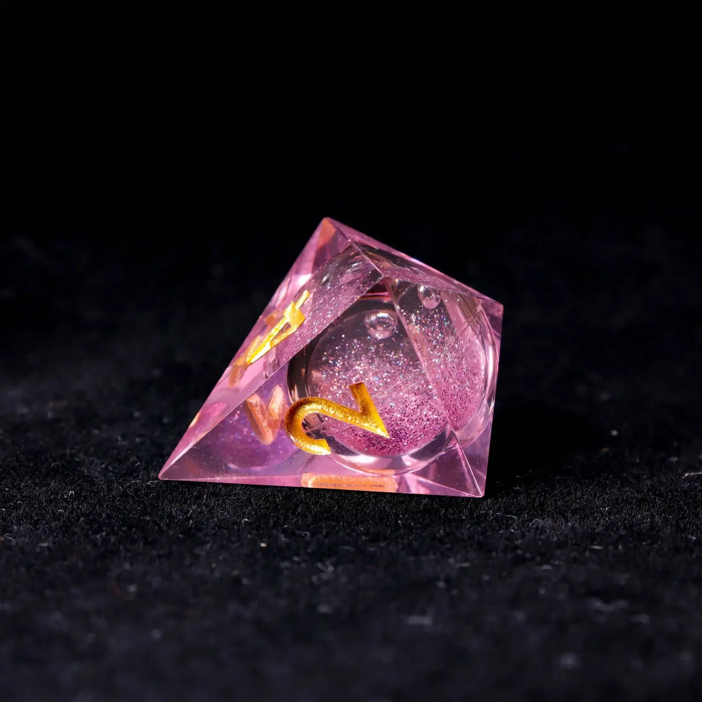Translucent pink liquid core dice captured under backlighting, showcasing the crystal-clear resin and precision-centered core.