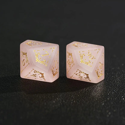 Two Pink Crystal dice (D10 and D%) together on black background, comparing sizes and engraved faces.