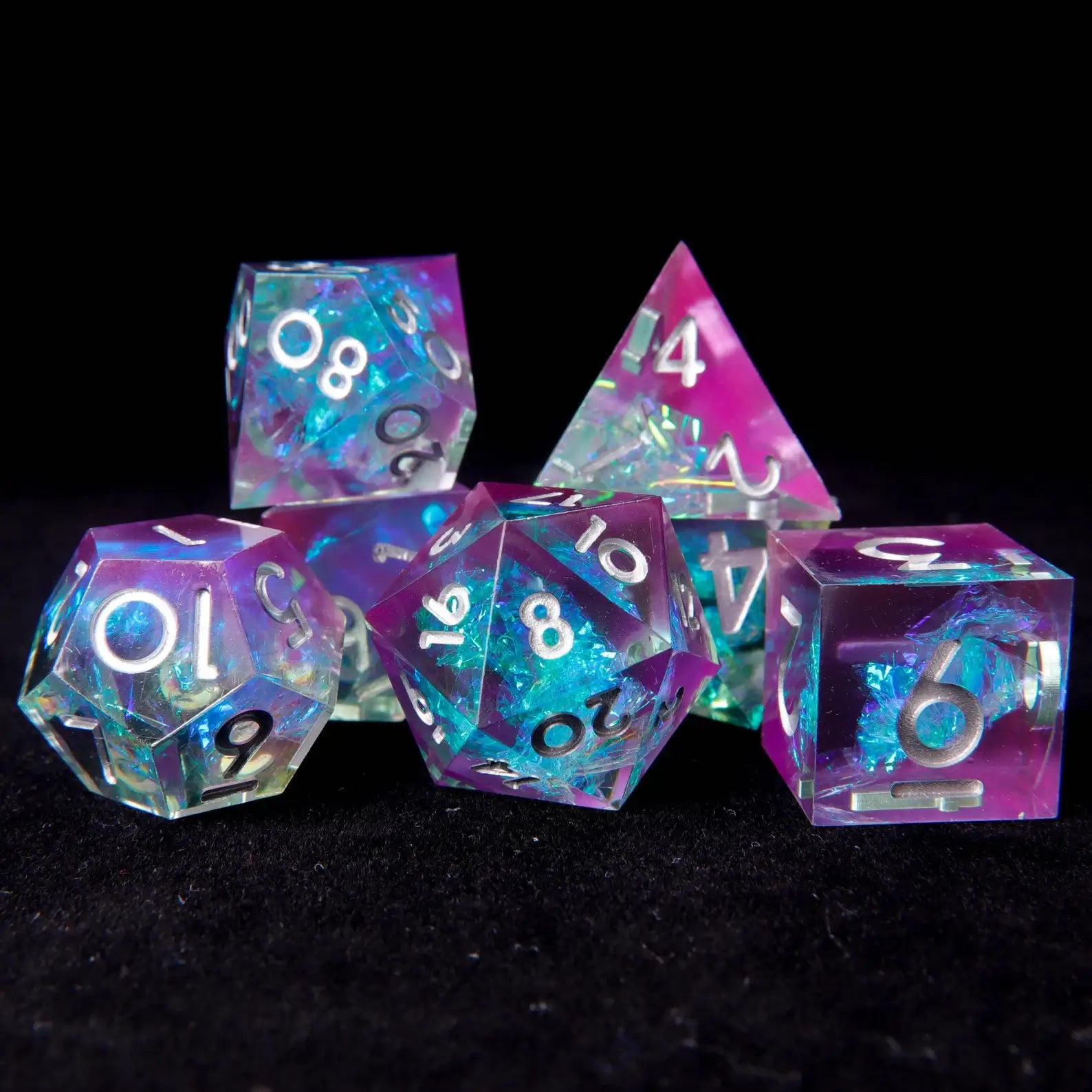 Overhead flat lay of the complete 7-piece RPG dice set arranged on a dark surface.