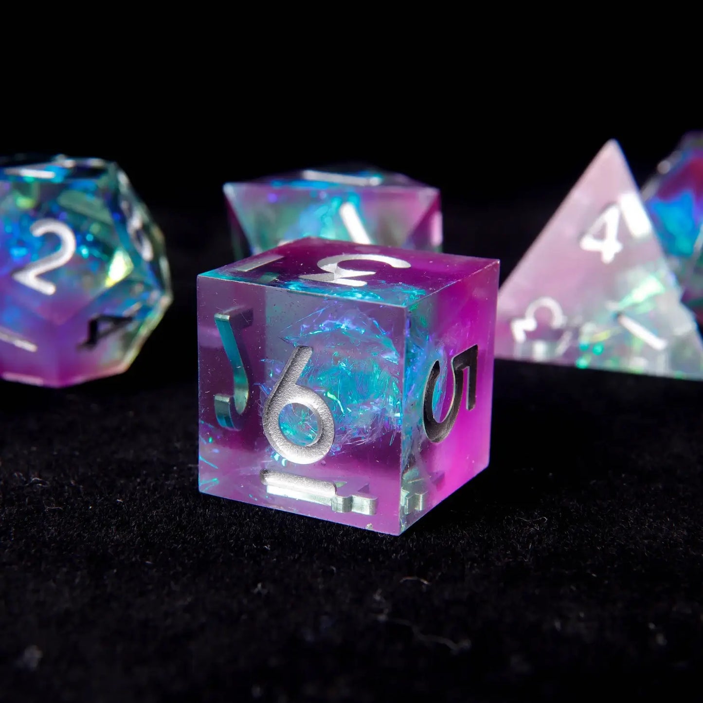 The dice set displayed with dramatic lighting, creating a nebula-like glow and showcasing its multidimensional color.