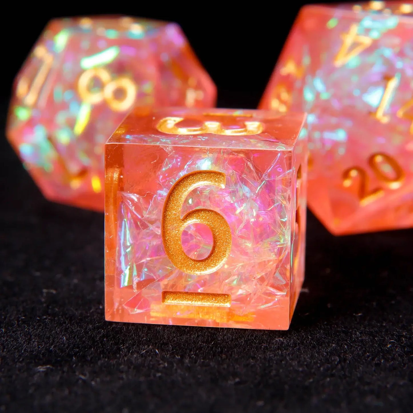 Vibrant orange and pink resin dice showing prismatic light refraction