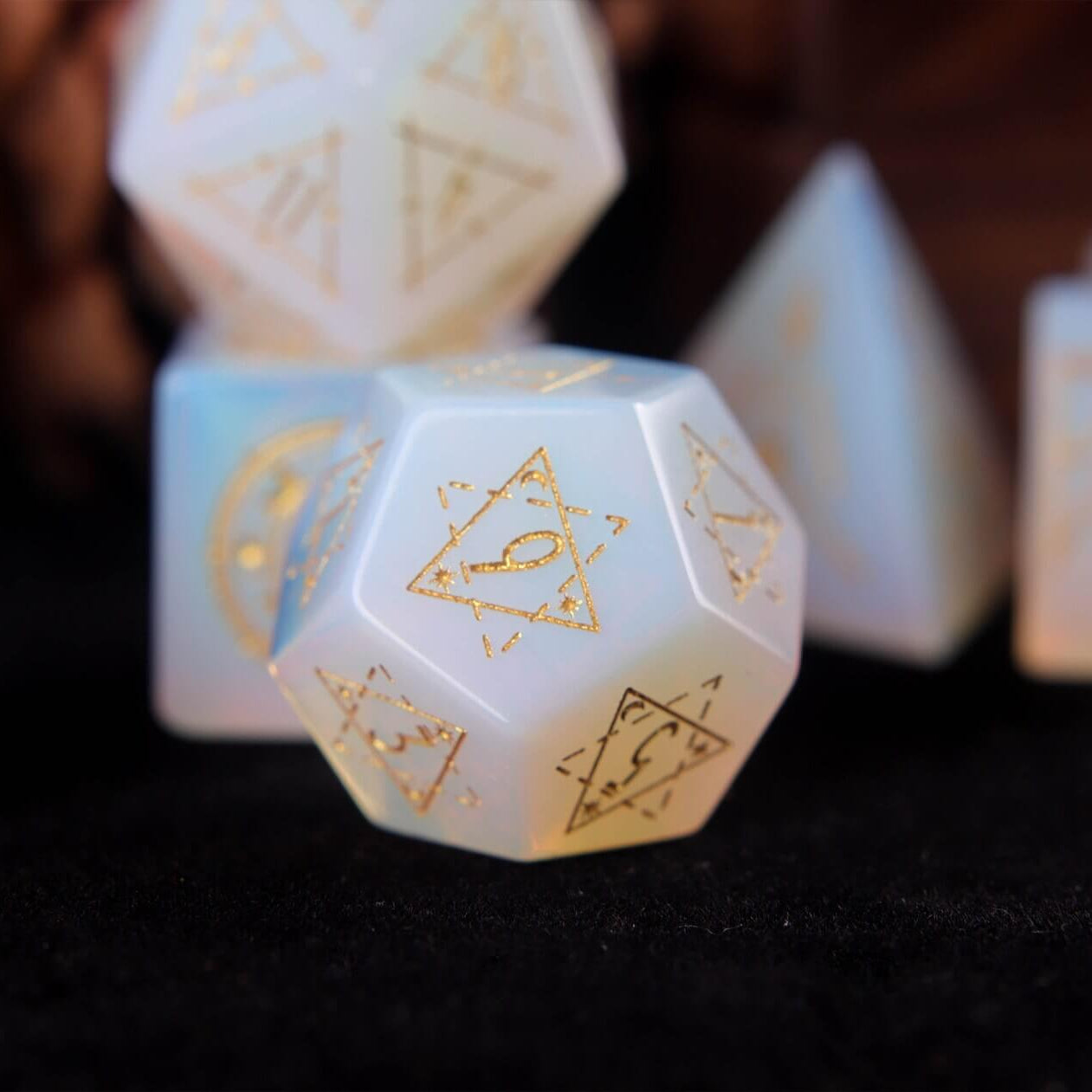 White opal D12 with translucent body and precision-etched geometric patterns.