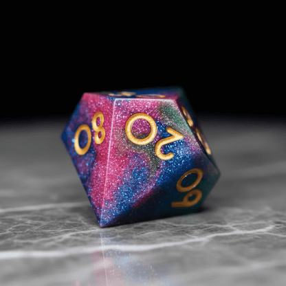 Close-up of zonal dye technique on resin polyhedral dice showing distinct pink and green areas.